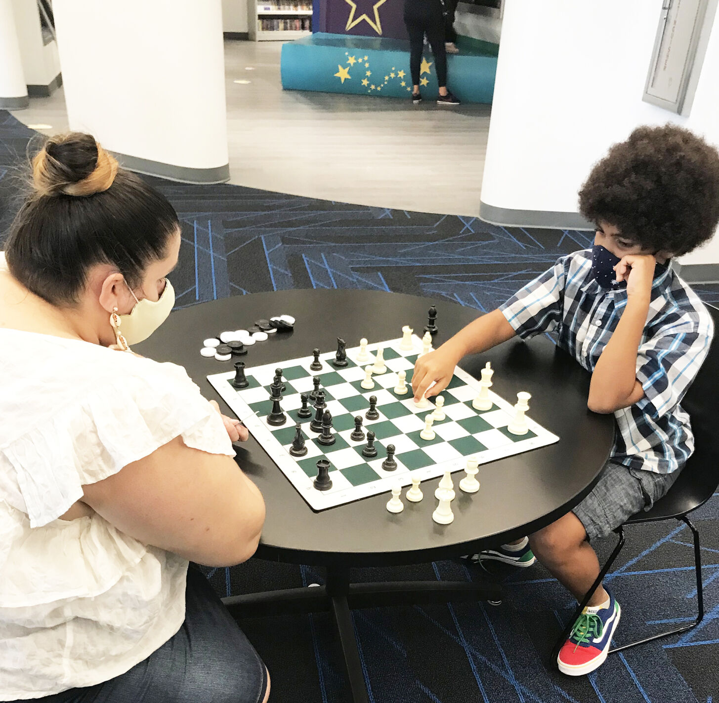 Nathaniel and his mom, Yanira, played a competitive game of chess at the Cybrarium.